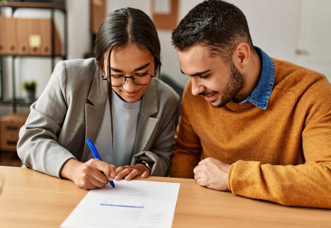 A man and a woman looking at documents to lower their debt to income ratio (DTI).