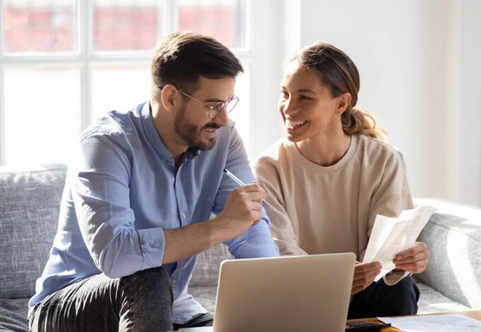 Couple sitting in front of computer calculates their mortgage payments and creates an amortization schedule.