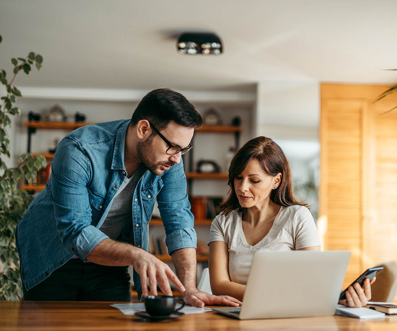 Couple at home discusses what a loan level price adjustment is while sitting at computer.