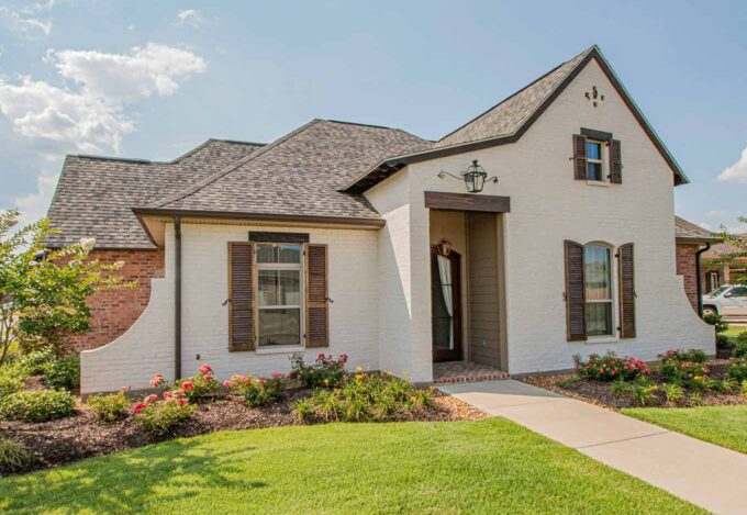 Exterior of cottage style home with whitewash brick style.